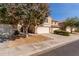 View of the home from the street, featuring a three-car garage and mature landscaping at 4122 E Jojoba Rd, Phoenix, AZ 85044