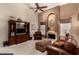Spacious living room featuring high ceilings, a ceiling fan, a fireplace, and plush furniture at 4122 E Jojoba Rd, Phoenix, AZ 85044