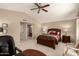 Warm main bedroom featuring a king bed and a glimpse into the ensuite bathroom at 4122 E Jojoba Rd, Phoenix, AZ 85044