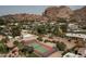Aerial view of tennis court surrounded by lush landscaping and homes with mountain views at 4442 E Camelback Rd # 161, Phoenix, AZ 85018