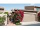 Charming home exterior with a blooming bougainvillea next to the garage and gated entrance at 4442 E Camelback Rd # 161, Phoenix, AZ 85018