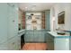 Eat-in kitchen with custom cabinetry, terracotta tile floors, and built-in desk at 4442 E Camelback Rd # 161, Phoenix, AZ 85018