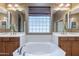 Bright and airy bathroom with dual vanities, a large soaking tub, and a stylish glass block window at 4521 W Hopi Trl, Laveen, AZ 85339