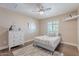 Bedroom with a twin bed, dresser, ceiling fan, wood floors, and neutral decor at 532 N 102Nd Pl, Mesa, AZ 85207