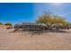 Large lot with trees, desert landscaping, and a trampoline with home and patio in the background at 532 N 102Nd Pl, Mesa, AZ 85207