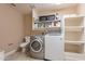 Convenient laundry room complete with a washer, dryer, shelving, and a toilet for added functionality at 532 N 102Nd Pl, Mesa, AZ 85207