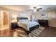 Spacious main bedroom featuring wood floors, ceiling fan, a large bed, and elegant furnishings at 532 N 102Nd Pl, Mesa, AZ 85207
