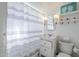 Traditional bathroom with black and white tiled floor, and a striped shower curtain at 541 W Edgemont Ave, Phoenix, AZ 85003