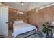 Bedroom includes brick wall, white bedding, overhead lights, and a door to the left at 541 W Edgemont Ave, Phoenix, AZ 85003