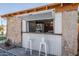 Charming exterior with a stone wall, white trim, and a built in bar with two stools at 541 W Edgemont Ave, Phoenix, AZ 85003