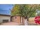 Cozy backyard featuring a brick patio, a small outbuilding and a vibrant citrus tree at 7548 E Minnezona Ave, Scottsdale, AZ 85251