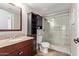 Bathroom featuring granite vanity, storage, and a tiled shower with glass doors at 8155 E Roosevelt St # 112, Scottsdale, AZ 85257