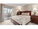 Cozy bedroom with balcony access, complemented by wood furniture and soft, neutral tones at 8155 E Roosevelt St # 112, Scottsdale, AZ 85257