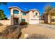 Charming two-story home with an attached two car garage, desert landscaping, and teal window frames at 8812 N 67Th Dr, Peoria, AZ 85345