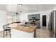 This kitchen features stainless steel appliances, an island, bar seating and dark wood cabinets at 8812 N 67Th Dr, Peoria, AZ 85345