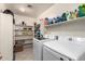 Laundry room featuring modern washer and dryer with shelving for storage and organization at 8812 N 67Th Dr, Peoria, AZ 85345