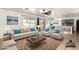 Open-concept living room with large windows, comfortable seating, and hardwood floors with view to dining area at 8812 N 67Th Dr, Peoria, AZ 85345