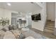 Spacious living room with a large TV, open access to the kitchen, and a staircase to the upper level at 9065 E Gary Rd # 121, Scottsdale, AZ 85260