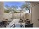 Private backyard patio with stone landscaping, an umbrella, two chairs, and access to the home at 9065 E Gary Rd # 121, Scottsdale, AZ 85260