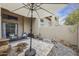 Relaxing backyard patio offers comfortable seating, an umbrella, stone landscaping, and building access at 9065 E Gary Rd # 121, Scottsdale, AZ 85260
