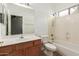 Bathroom with single sink vanity, toilet, and shower-tub combo with white tile surround at 9237 W Alex Ave, Peoria, AZ 85382