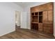 This bedroom features a built-in wood desk and shelving, wood-look floors, and a view into the hall at 9237 W Alex Ave, Peoria, AZ 85382