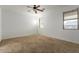 A carpeted bedroom features a ceiling fan and large windows that provide plenty of natural light at 9237 W Alex Ave, Peoria, AZ 85382