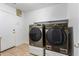 Well-lit laundry room with side-by-side Samsung washer and dryer on white pedestals at 9237 W Alex Ave, Peoria, AZ 85382