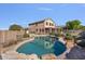 Beautiful backyard pool with lush landscaping and a covered patio at 9237 W Alex Ave, Peoria, AZ 85382