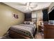 Bedroom with a ceiling fan, dark curtains, and a patterned bed with accent pillows at 9263 E Monterey Ave, Mesa, AZ 85209