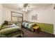 Bright bedroom with two beds, a ceiling fan, a green accent wall, and a small table at 9263 E Monterey Ave, Mesa, AZ 85209
