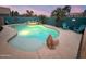 Beautiful pool with a fire pit surrounded by palm trees and outdoor seating at dusk at 9263 E Monterey Ave, Mesa, AZ 85209