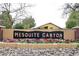 Welcoming Mesquite Canyon community entrance with colorful flowerbeds at 9658 E Olla Ave, Mesa, AZ 85212