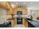 Well-lit kitchen featuring natural wood cabinetry, stone backsplash, granite countertops, and modern appliances at 9718 E Boston St, Mesa, AZ 85207