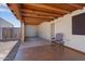 Covered patio featuring a comfortable chair, concrete floors, and rustic wood beams at 9718 E Boston St, Mesa, AZ 85207