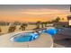 Backyard oasis with a pool and spa, framed by desert plants and bathed in the warm glow of the evening sun at 9734 S 182Nd Dr, Goodyear, AZ 85338