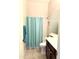 Bright bathroom featuring a vanity with double sinks, tiled floors, and a shower with a stylish curtain at 9734 S 182Nd Dr, Goodyear, AZ 85338
