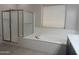 Bright bathroom with soaking tub, walk-in shower and ample natural light at 9734 S 182Nd Dr, Goodyear, AZ 85338
