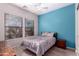 Bright bedroom with a blue accent wall, two windows, and hardwood floors at 9734 S 182Nd Dr, Goodyear, AZ 85338