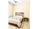 Simple bedroom with a wooden bed frame, side table, and light wood-look flooring at 9734 S 182Nd Dr, Goodyear, AZ 85338