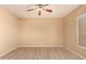 Well-lit bedroom with light wood floors, a ceiling fan, and a single window creating a peaceful and serene atmosphere at 9734 S 182Nd Dr, Goodyear, AZ 85338