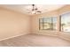 Bright bedroom with light wood floors, a ceiling fan, and large windows offering plenty of natural light at 9734 S 182Nd Dr, Goodyear, AZ 85338