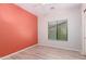 Bedroom with an orange accent wall, ceiling fan, and a window that brings in natural light at 9734 S 182Nd Dr, Goodyear, AZ 85338