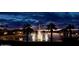 Gorgeous community pond with fountains, lush landscape, and vibrant sunset hues at 9734 S 182Nd Dr, Goodyear, AZ 85338