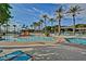 Community pool featuring waterslide, various lounge areas, and lush palm tree landscaping at 9734 S 182Nd Dr, Goodyear, AZ 85338