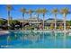 Stunning community pool with ample seating, shade umbrellas, and a beautifully designed clubhouse backdrop at 9734 S 182Nd Dr, Goodyear, AZ 85338