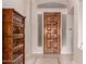 Inviting foyer with a dark wood front door, stylish tile, and built in glass shelves at 9734 S 182Nd Dr, Goodyear, AZ 85338