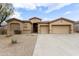 Charming home featuring a large driveway, three-car garage, and a well maintained desert landscape at 9734 S 182Nd Dr, Goodyear, AZ 85338