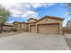 Charming home with a well-maintained desert landscape, spacious driveway, and three-car garage at 9734 S 182Nd Dr, Goodyear, AZ 85338
