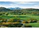 Scenic golf course view showcasing lush green fairways and desert landscape, nestled amongst rolling hills and mountain backdrop at 9734 S 182Nd Dr, Goodyear, AZ 85338